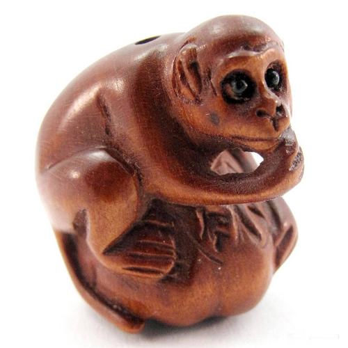 Monkey Ojime Bead of a Monkey sitting on a pumpkin